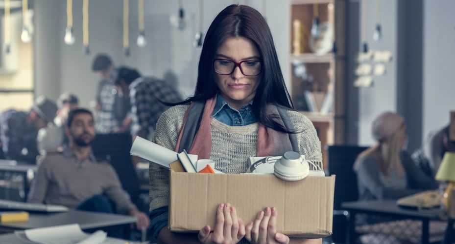 teacher carrying box of belongings after teacher layoffs