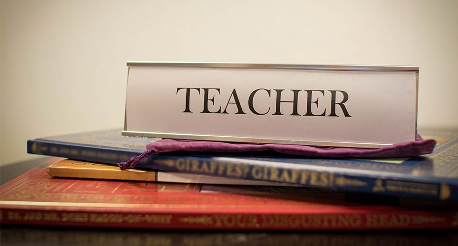 desk sign that says teacher representing a symbol of pride in the career