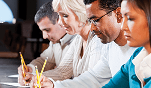 four people concentrating on taking a test