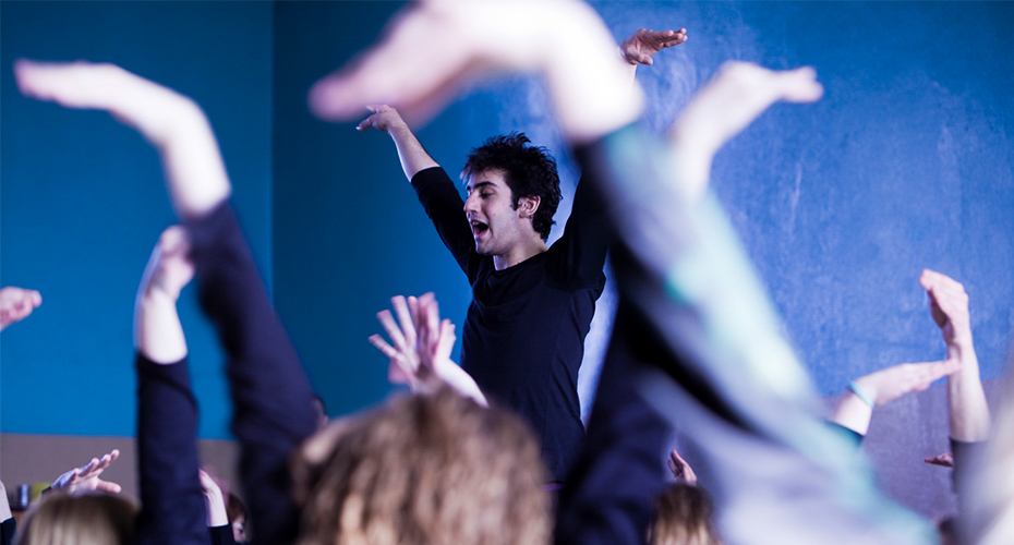 teacher leads a drama class in movement exercises