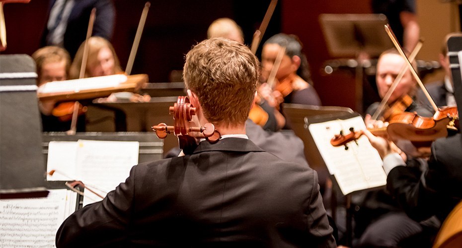music teacher conducting school student symphony performance