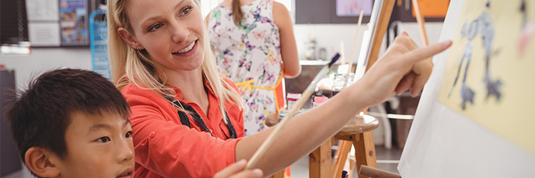 art teacher critiques young student painting