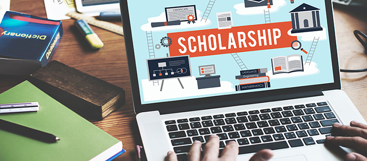 hands on laptop looking for scholarships
