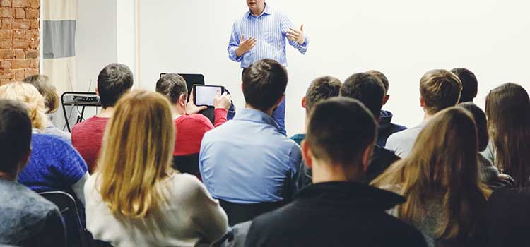 teacher leads classroom of adult learners
