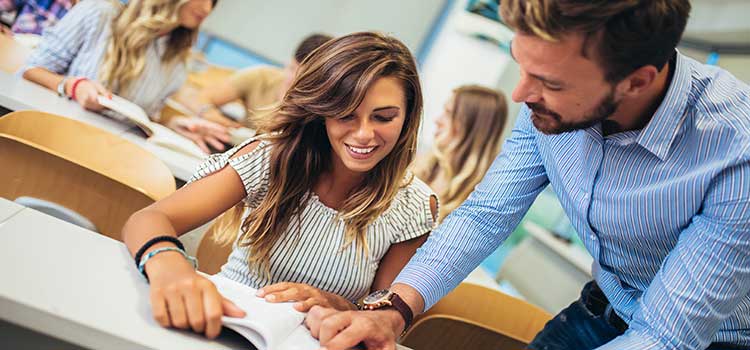 teacher and student reviewing textbook
