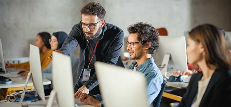 teacher helping adult computer learners
