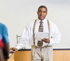 african american teacher lecturing to class full of students