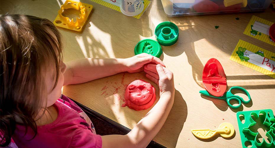 young girl doing arts and crafts in elementary school classroom