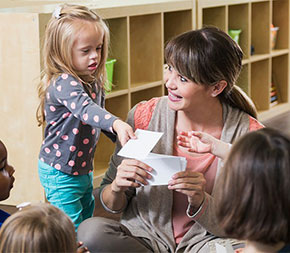 special education teacher sitting in circle with special needs children