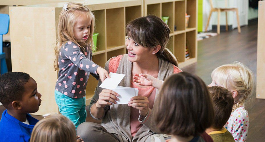 special education teacher sitting in circle with special needs children