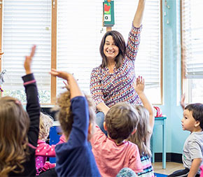 enthusiastic teacher with special education degree encourages class of special needs kids to raise hands