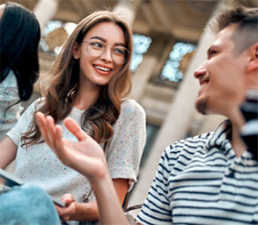diverse students smiling outside of building