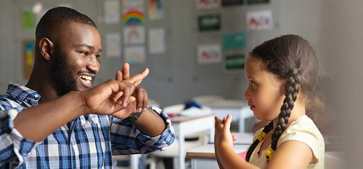 sign language teacher signs with a child student
