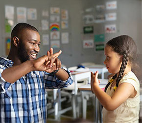 sign language teacher signs with a child student